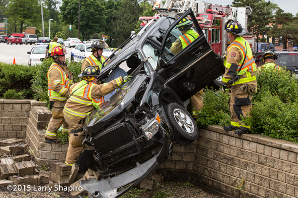 SUV tangles over retention wall after crash