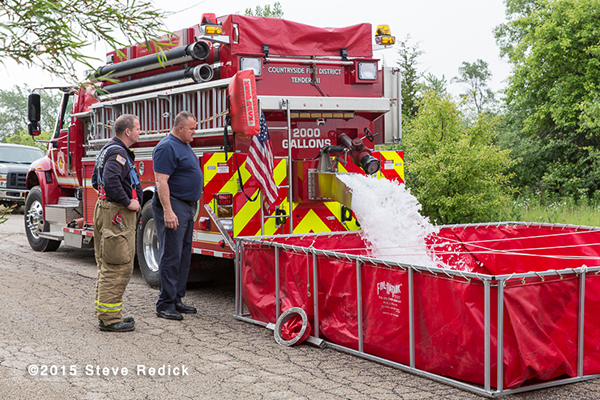 fire departmetn water tender dumping into a portable tank