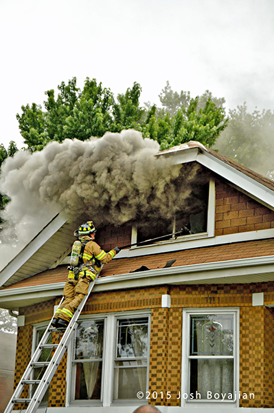 heavy smoke from the attic of a house on fire