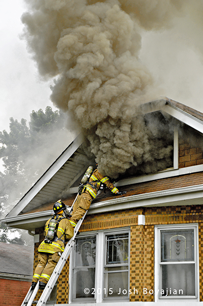 heavy smoke from the attic of a house on fire