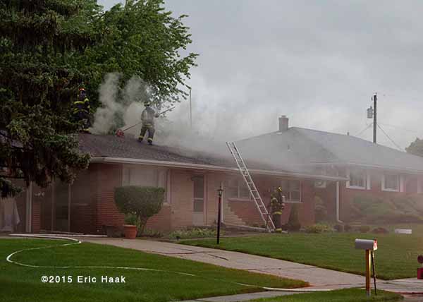 fireman on the roof of a house with smoke