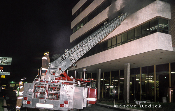 firemen make ladder rescue at office building fire