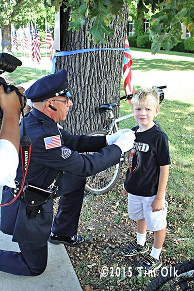 police officer pins award to young boy