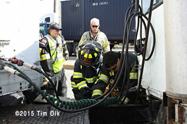 firemen monitor diesel spill at truck crash