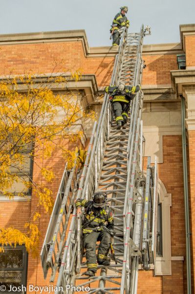firemen climb E-ONE aerial ladder