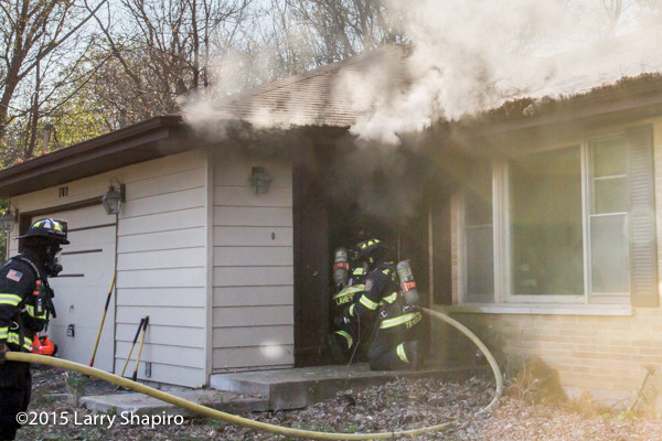 firefighters enter house under smoke
