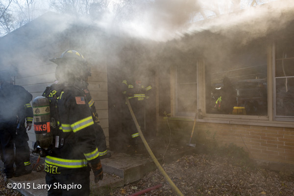 firefighters enter house under smoke