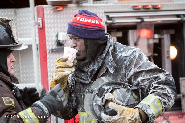 firefighter covered with ice drinking coffee