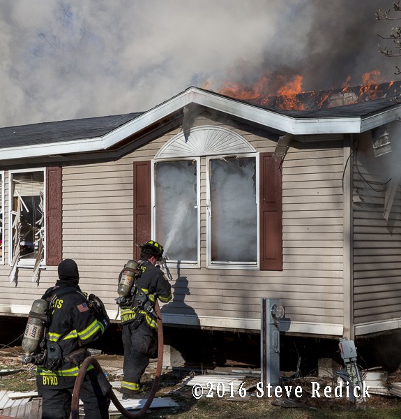 firefighters battle fire in a mobile home