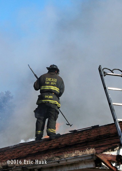 A Chicago firefighter vents the roof at house fire