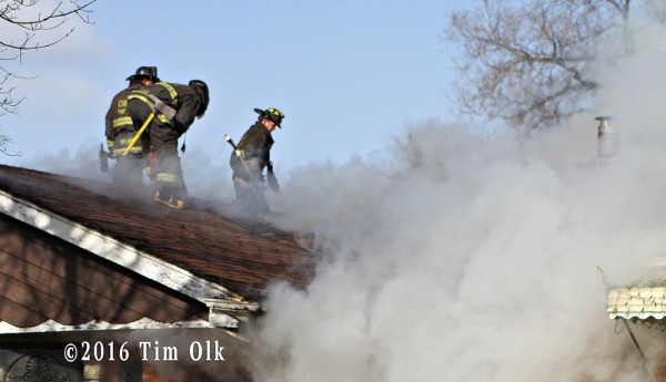 Chicago firefighters vent roof at house fire
