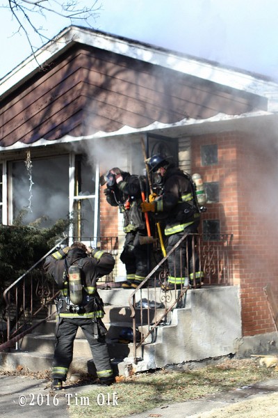 firefighters make entry to house fire
