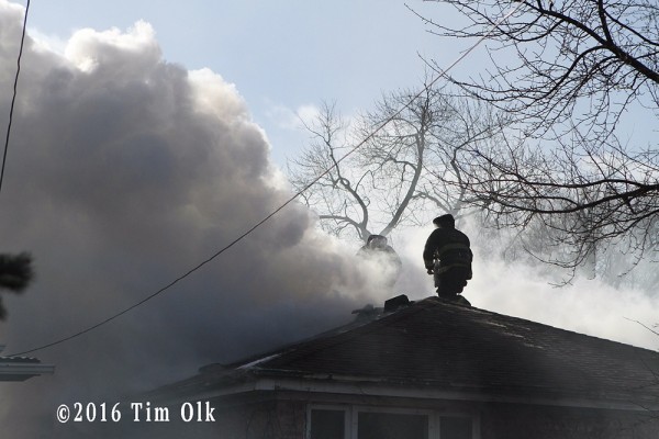 Chicago firefighters vent roof at house fire