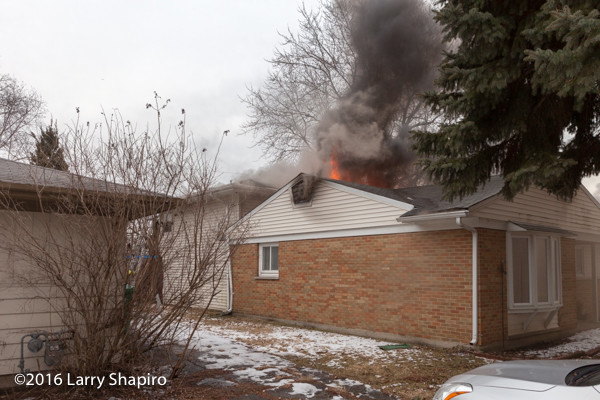 flames and smoke through roof of house
