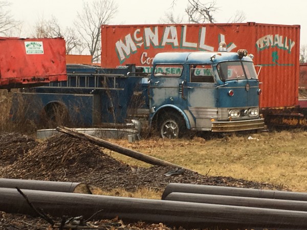 unidentified blue C Model Mack fire engine rusting in a field