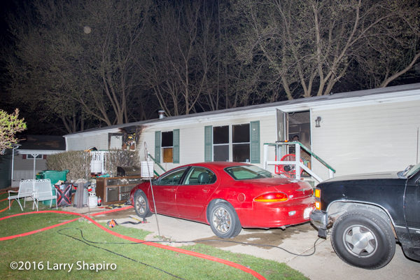 firefighters battle a mobile home fire