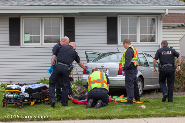 firefighters attend to accident victim on the ground