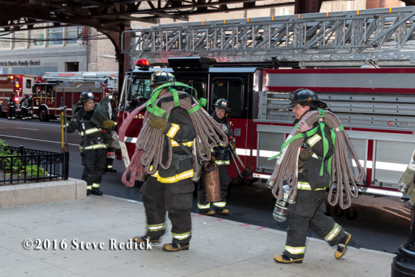 firemen carry high-rise hose packs