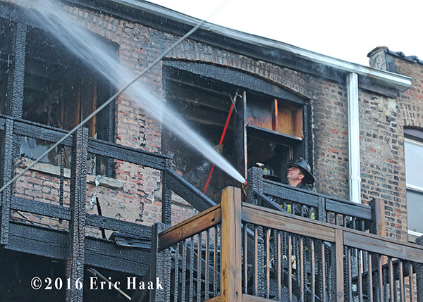 firefighter overhauls after back porches burn