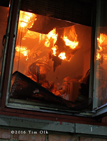fiery debris falls on firefighter pulling ceiling