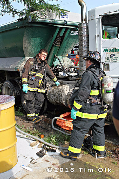 Chicago FD haz mat techs clean diesel fuel spill from ruptured saddle tank