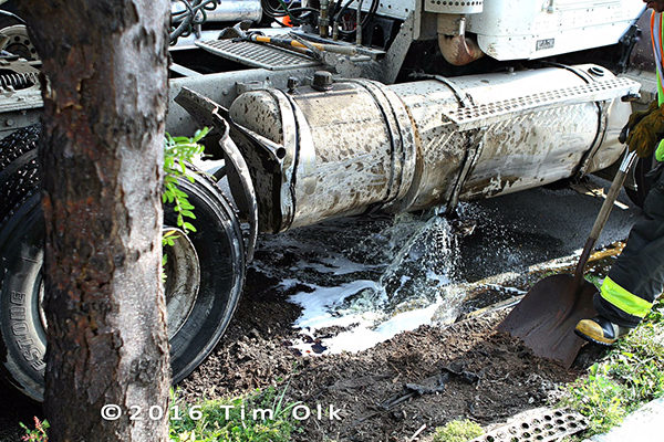 Chicago FD haz mat techs clean diesel fuel spill from ruptured saddle tank