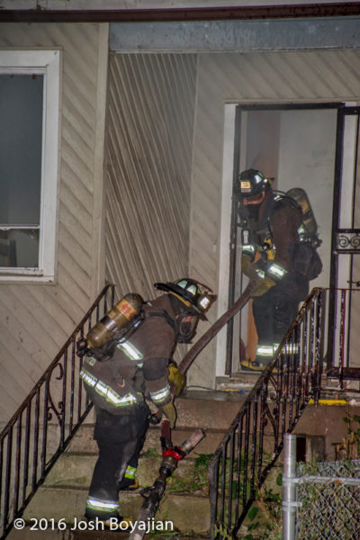 firefighters enter house with hose