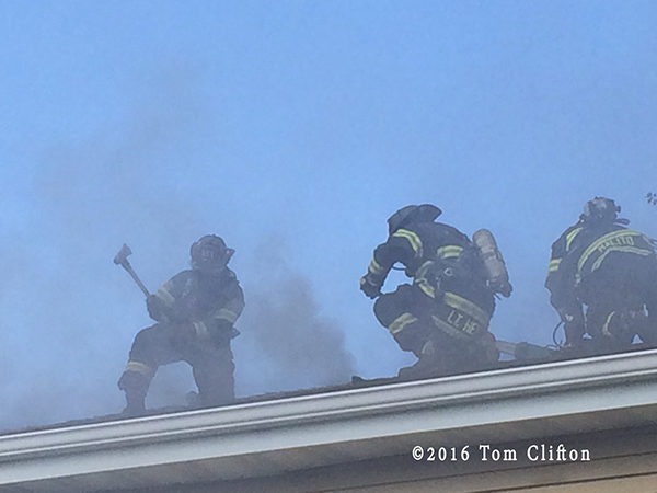 firefighters on roof at house fire