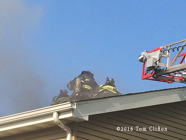 firefighters on roof at house fire
