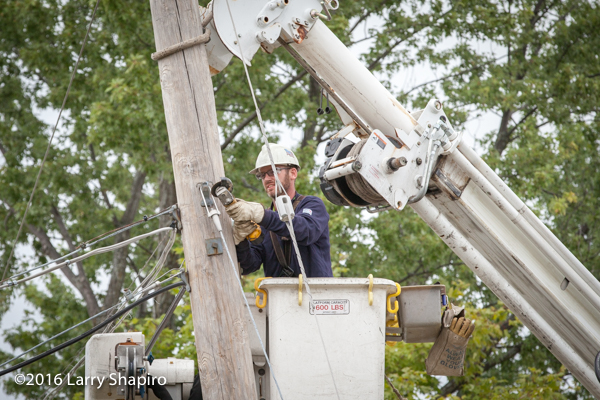 lineman secures utility pole