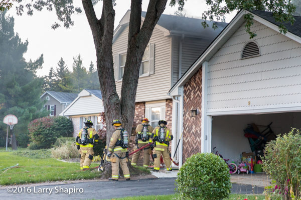 firefighters prepare to enter house on fire