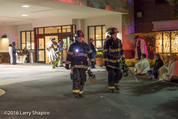 firefighters at night with tools and PPE walking