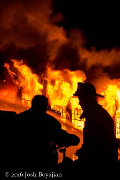 silhouette of firefighters at a massive warehouse fire in Chicago