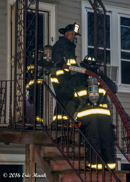 firefighters enter a house with a hose line