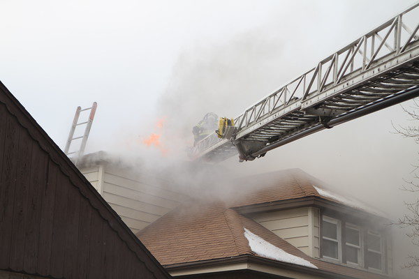 Firefighters vent roof with flames
