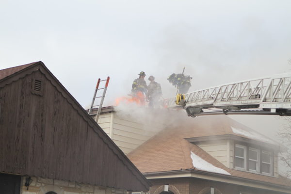 Firefighters vent roof with flames