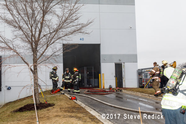 firefighters standby at warehouse fire