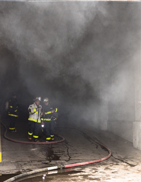 heavy smoke pours out of warehouse
