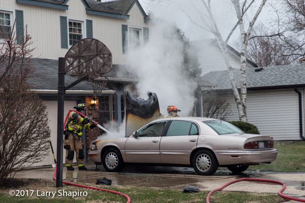 Firefighters extinguish a car fire