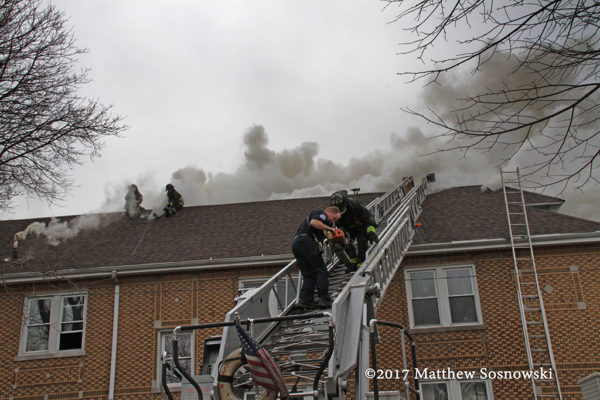 firefighters climb aerial ladder at fire