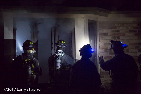 Firefighters prepare to enter house on fire