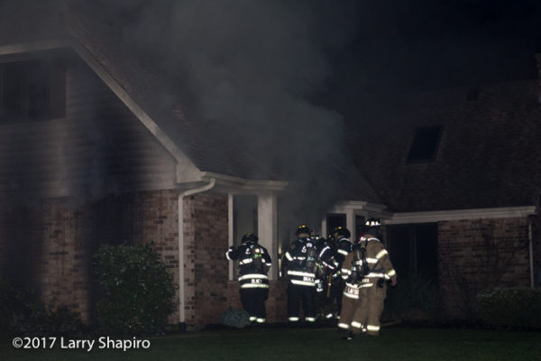 firefighters battle smokey house fire from outside 
