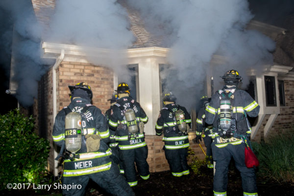 firefighters fight basement fire from outside