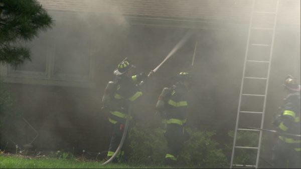 firefighters with hose at fire scene
