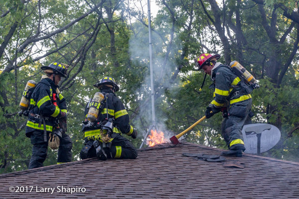 Firefighters vent roof of a house