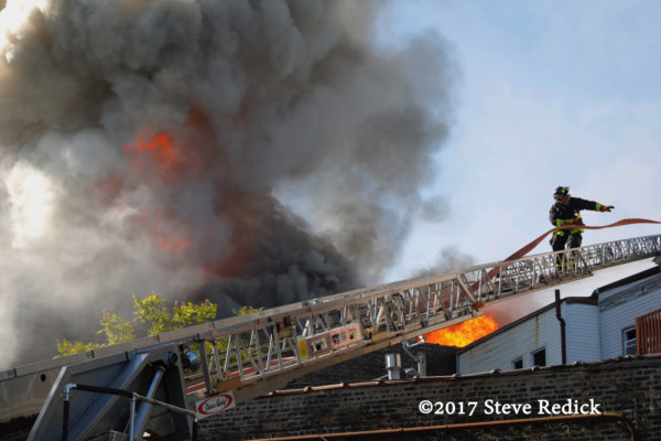 firefighter on aerial ladder with fire