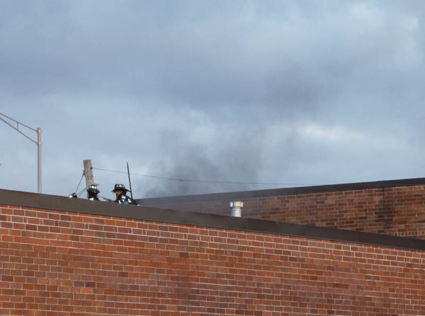 firefighters on roof with smoke
