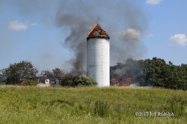 silo stands amid barn destroyed by fire