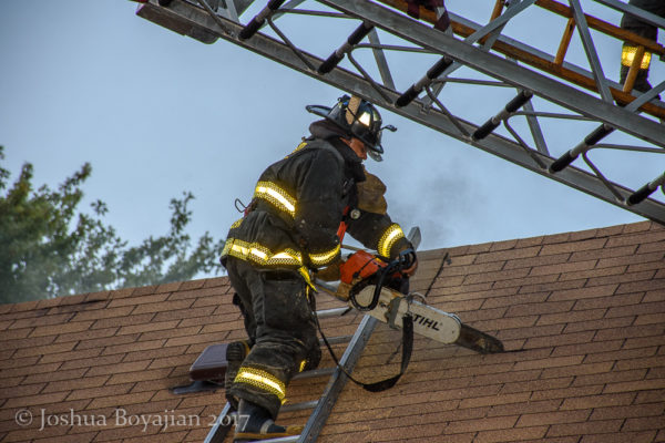 Firefighter vents roof with a saw
