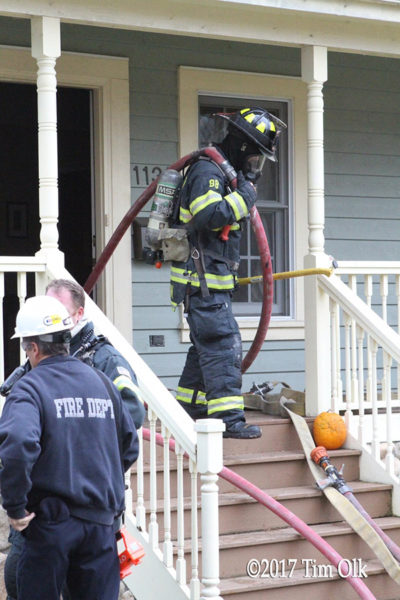 firefighter with hose line after a fire